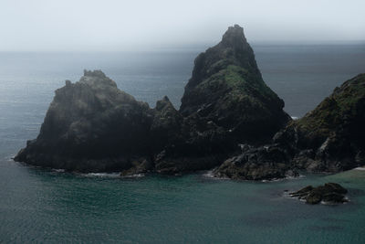 Rock formations by sea against sky