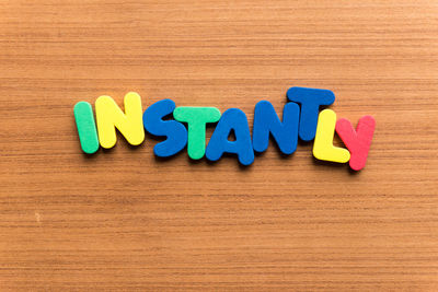 Directly above shot of multi colored text on wooden table