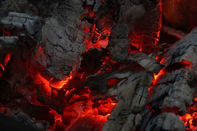 Smoldered logs burned in vivid fire close up. atmospheric background with flame.