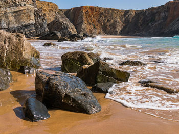 Rocks on beach by sea