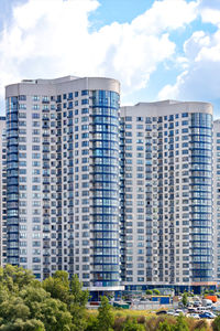 White and blue rounded facades of residential high-rise buildings in residential area of the city.