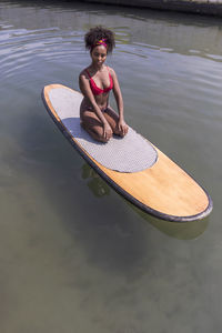 Woman sitting by swimming pool in lake