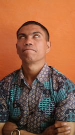 Portrait of young man standing against wall