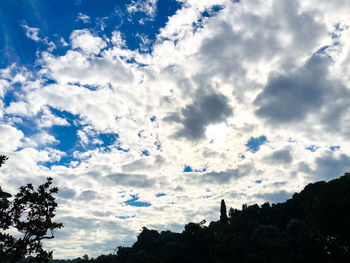 Low angle view of silhouette trees against blue sky