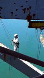 Worker on boat against blue sea