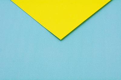 Close-up of yellow paper against blue background