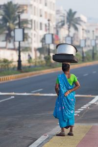 Women standing near road with containers