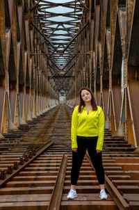 Portrait of young woman walking on railway