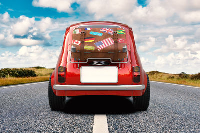 Red toy car on road against sky
