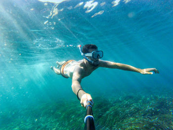 Full length of shirtless man swimming in sea