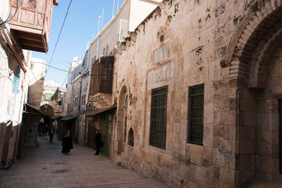 People walking on street amidst buildings in city