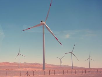 Windmill on field against sky