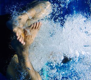 Low section of man swimming in pool