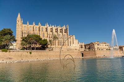 Historic building by river against clear sky