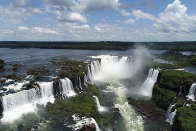 Scenic view of waterfall against sky