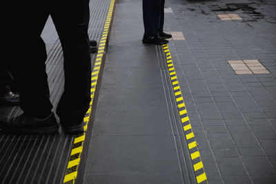 Low section of man standing on road