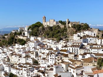 Buildings in town against clear blue sky