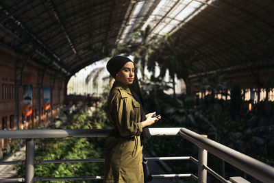 Portrait of young woman standing in building