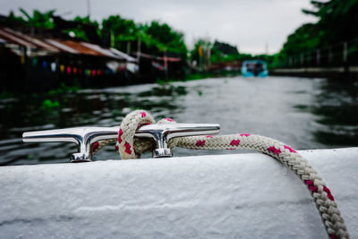 Close-up of railing by river in city