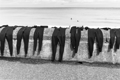 Clothes drying on beach by sea against sky