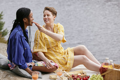 Female couple having picnic by river