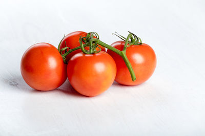 Close-up of tomatoes on table against white background