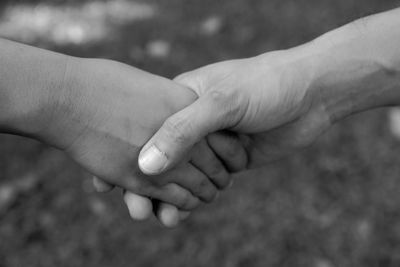 Midsection of couple holding hands