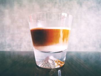 Close-up of coffee on table against wall