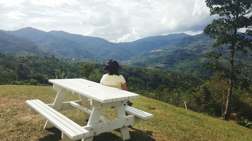 Rear view of woman relaxing on chair