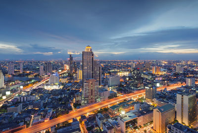 Illuminated cityscape against sky during sunset