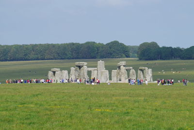 Group of people on field against sky