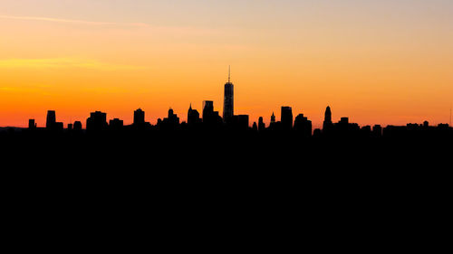 Silhouette buildings against sunset