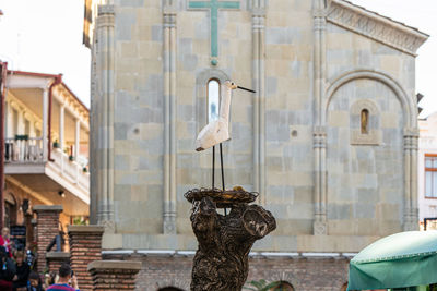 Statue against building in city