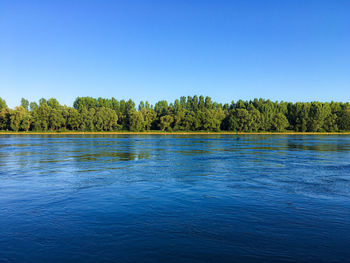 Scenic view of lake against clear blue sky