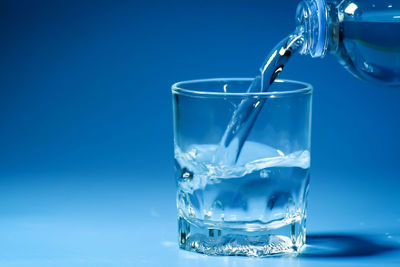 Close-up of water in glass against blue background