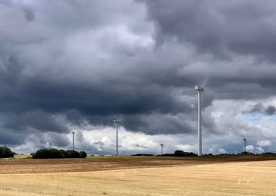 Scenic view of field against cloudy sky