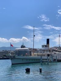 Sailboats moored at harbor against sky