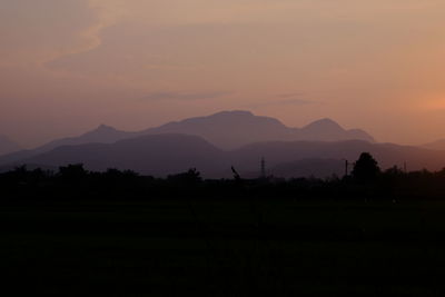 Scenic view of silhouette mountains against sky at sunset