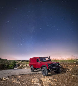 Tractor on field against clear sky at night