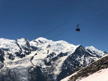 Scenic view of snowcapped mountains against clear blue sky