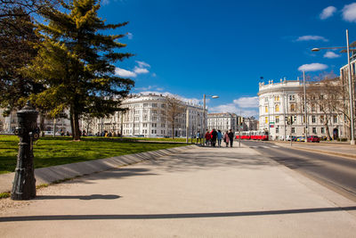 People on road in city against sky