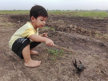 High angle view of cute boy sitting on field