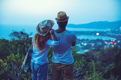 Rear view of couple standing against sky