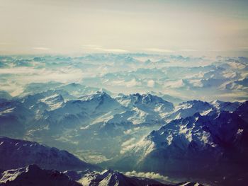 Aerial view of snowcapped mountains against sky during winter