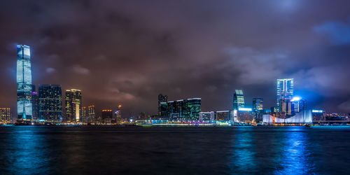 Illuminated buildings in city against sky at night