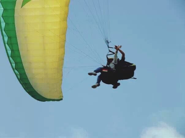 low angle view, leisure activity, lifestyles, mid-air, extreme sports, adventure, fun, sky, men, enjoyment, blue, flying, freedom, full length, parachute, sport, clear sky