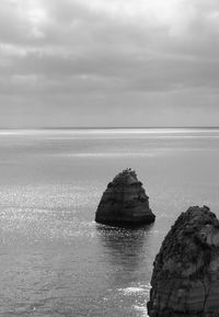 Rock formation in sea against sky