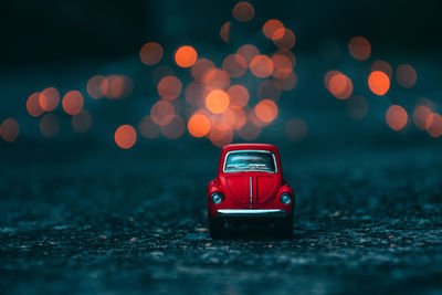 Red toy car on street at night