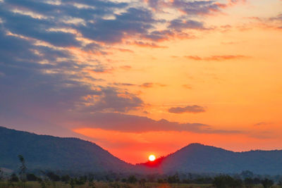 Scenic view of silhouette mountains against romantic sky at sunset