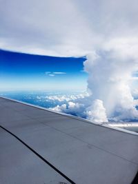 Cropped image of airplane flying over clouds